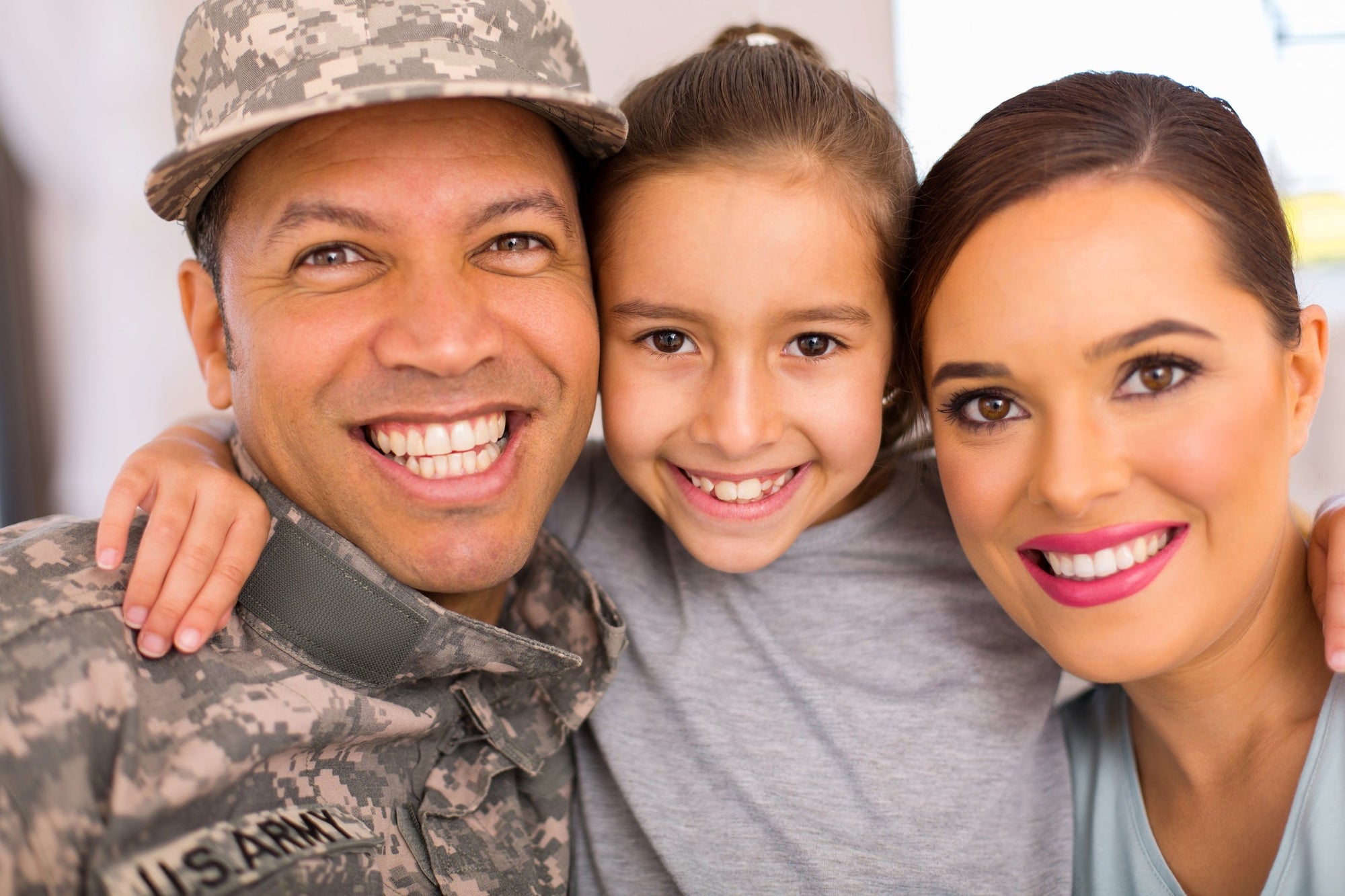 A happy military family hugs for a family photo, symbolic of military support through vocational discounts.