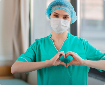 A nurse makes a heart symbol with her hands in appreciation for her nurse discount.